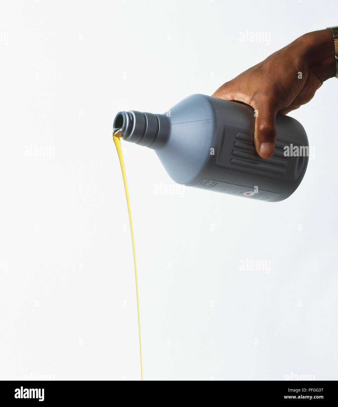 Gießen Motor Öl aus einer Kunststoffflasche Stockfoto