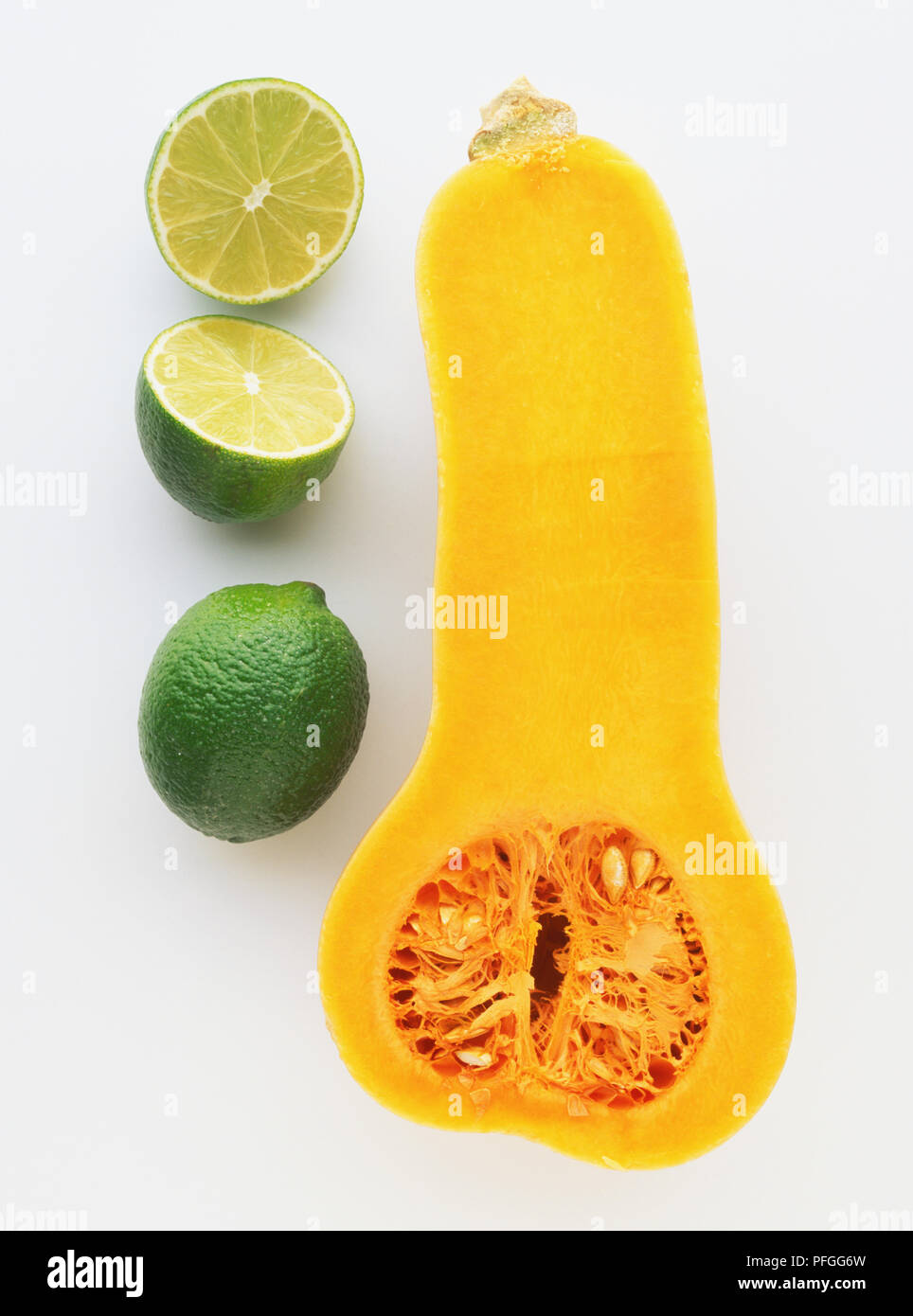 Citrus sp., Limes, ganz und halbiert, und einen Querschnitt der Cucurbita moschata, Butternut Kürbis Stockfoto