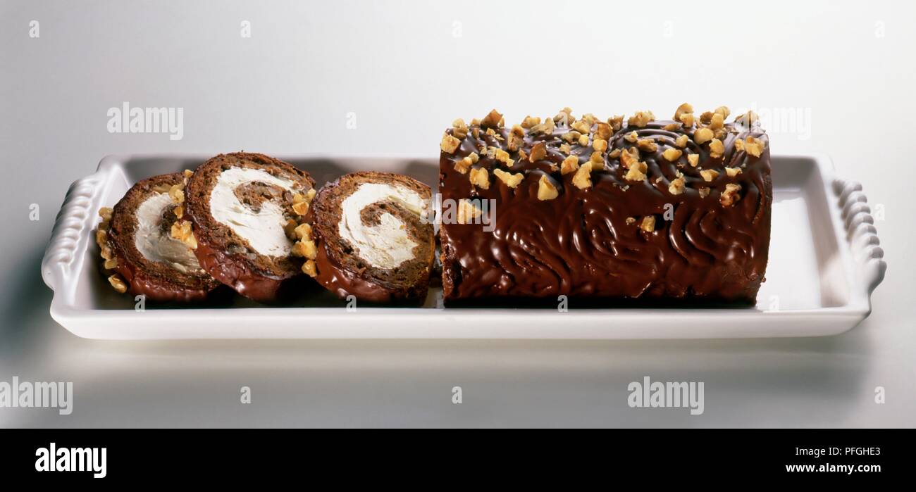 In Scheiben geschnitten piskota Kuchen mit Buttercreme mit Schokolade und Nüssen garniert gefüllt Stockfoto