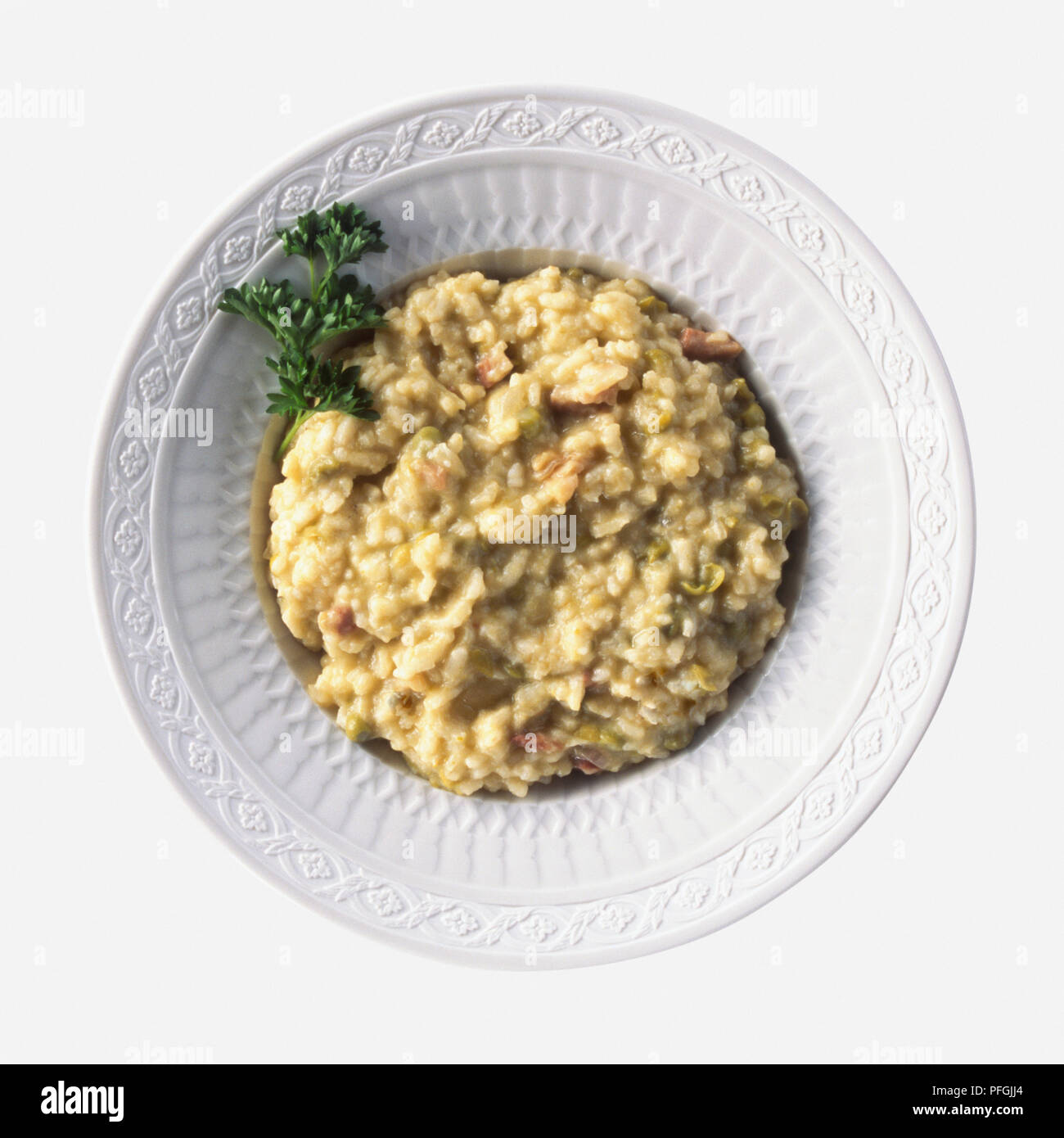 Platte von Risi e Bisi, Risotto mit Erbsen und Schinken gemacht und mit Petersilie garniert, ein typisches Gericht aus dem Veneto, Italien, Ansicht von oben Stockfoto