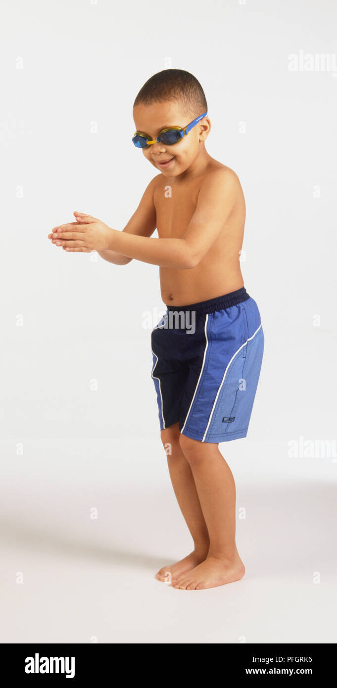 Ein junger Mann, Badeshorts und Schutzbrille mit seinen Händen vor Stockfoto