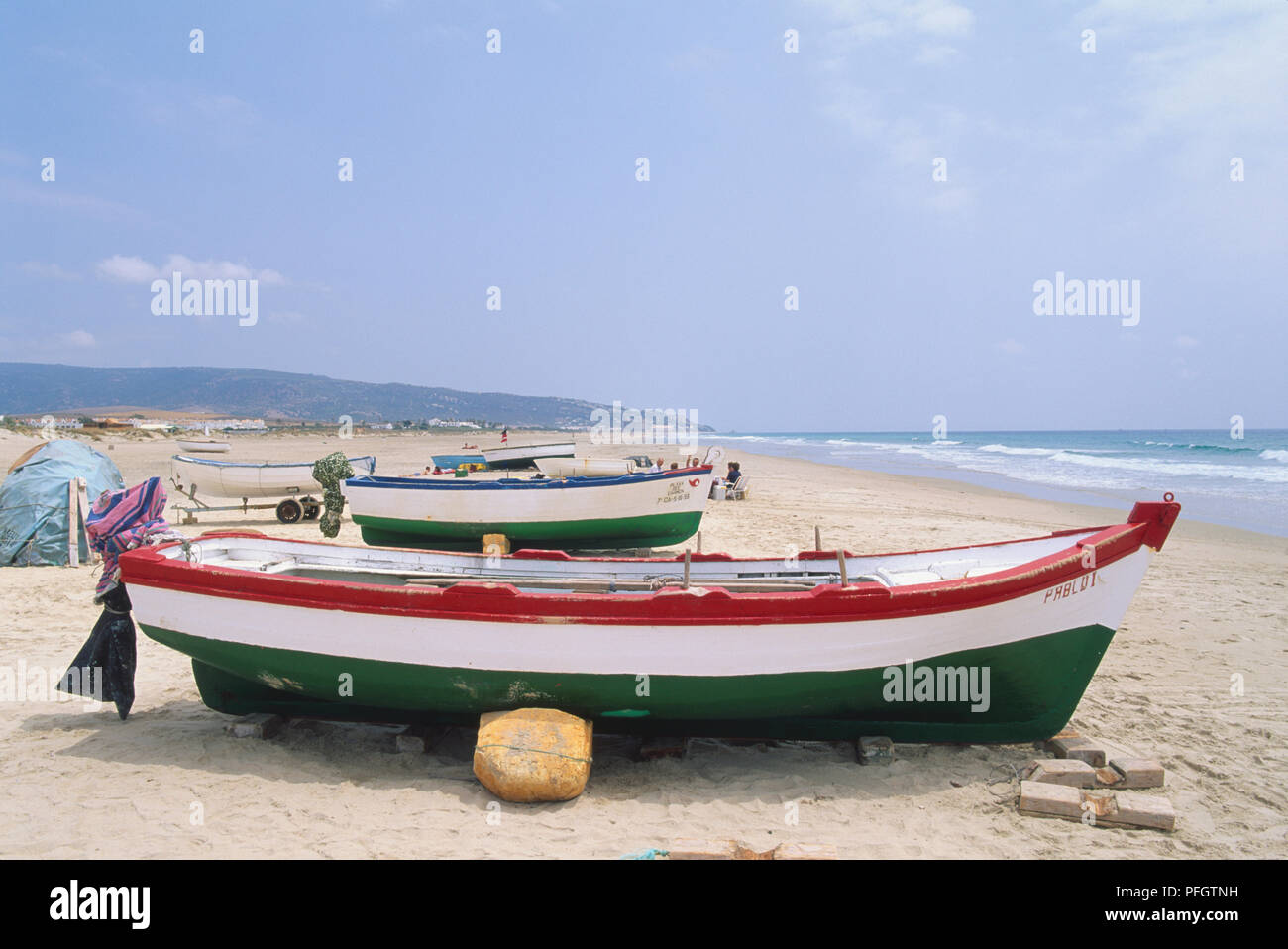 Spanien Andalusien, roten, weißen und grünen Holzboote auf sandigen Ufer. Stockfoto