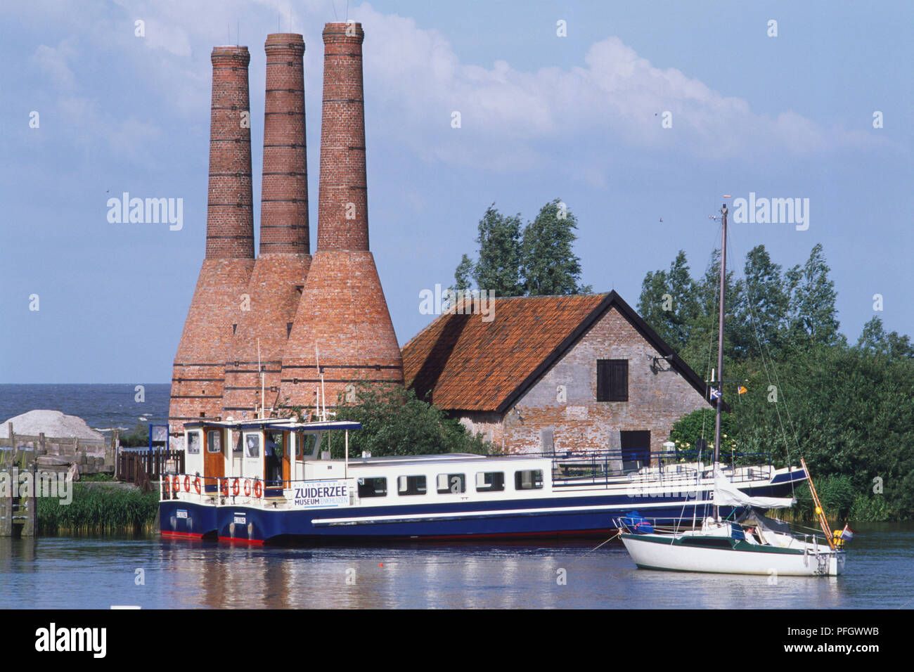 Holland, Zuiderzee Museum, Flasche geformte Kalköfen im Hintergrund mit einem Kanal und Boote im Vordergrund. Stockfoto