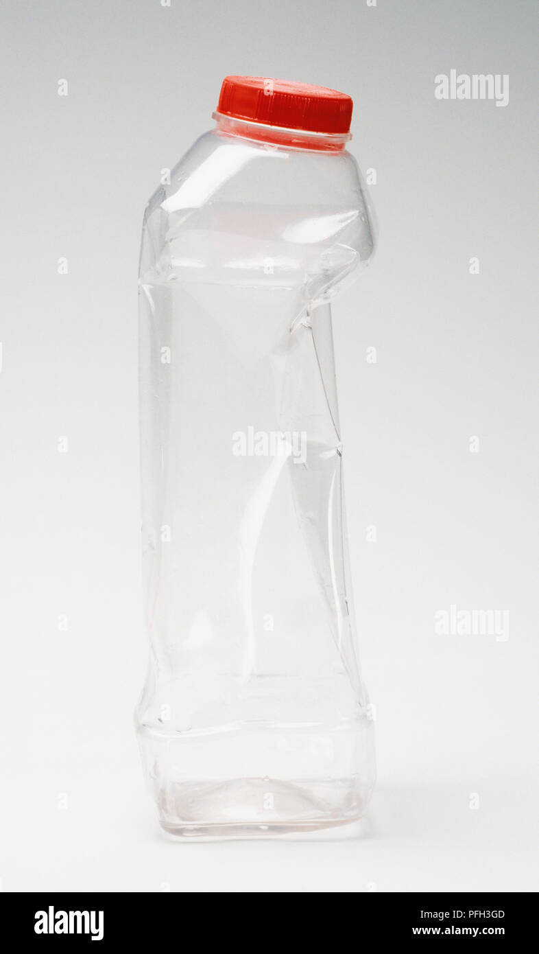 Leer und leicht gequetscht aus klarem Kunststoff Flasche mit rotem Deckel Stockfoto
