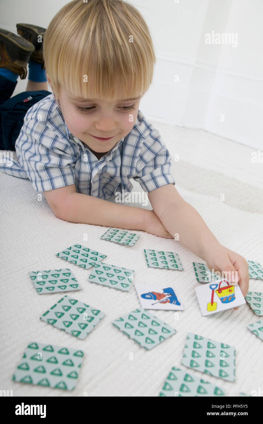 Junge lag auf dem Boden Karten memory spiel, lächelnd Stockfoto
