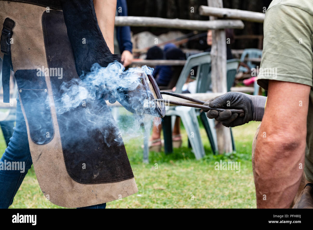 Nahaufnahme der menschlichen Hände Hot Shoe auf Pferd Paw Stockfoto