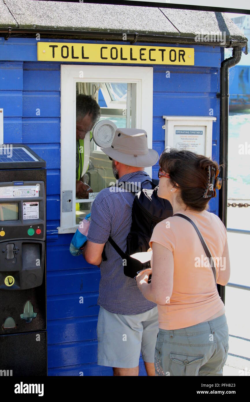 Sandbänke, Dorset, England - Juni 02 2018: Mann und Frau Queuing in Linie an das Ticket oder Maut collector stand für die Sandbänke zu Shell Bay Kette F Stockfoto