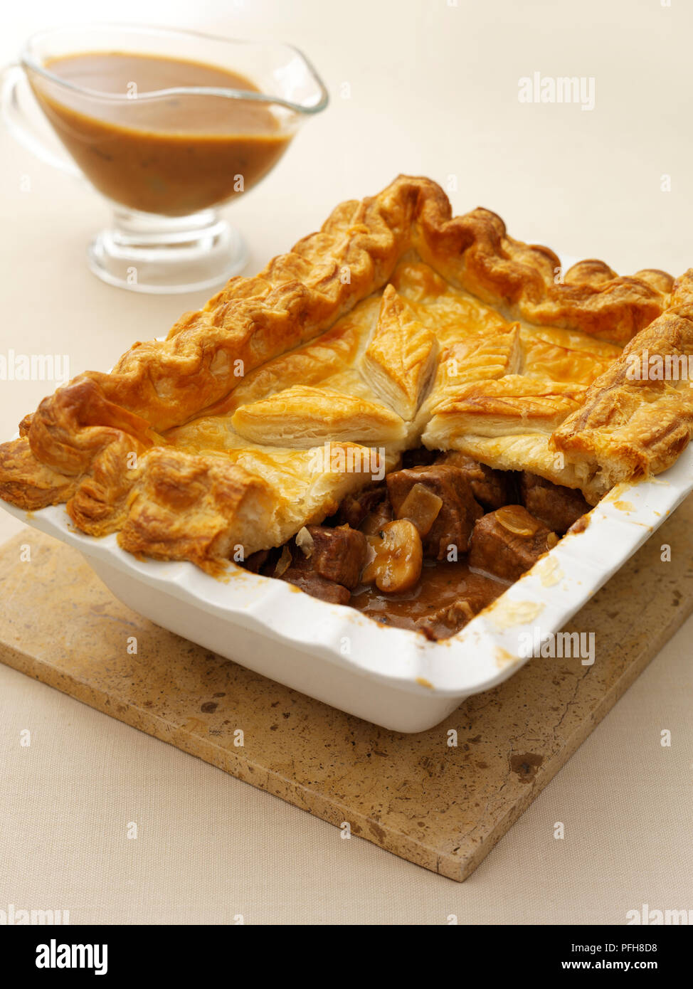 Steak und Ale-Torte mit einem Teil der Erdkruste entfernt Füllung, Soße Boot, nahe - bis zu zeigen Stockfoto