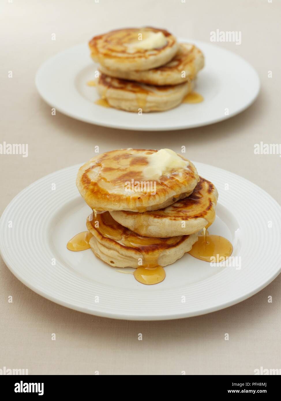 Zwei Platten von Scotch Pfannkuchen serviert mit zerlassener Butter und Honig, close-up Stockfoto
