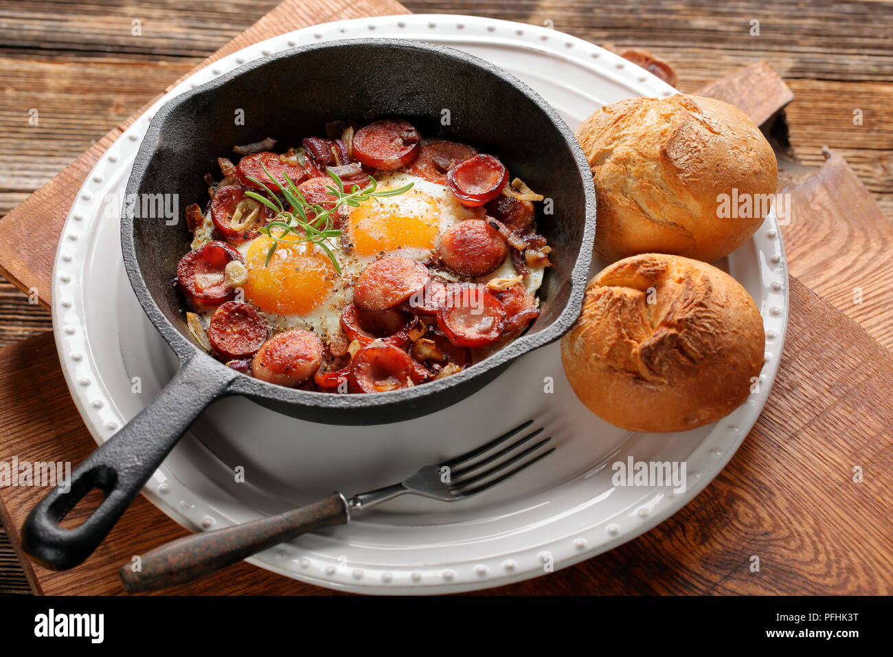 Gekochte Eier und Würstchen auf Pfanne Stockfoto