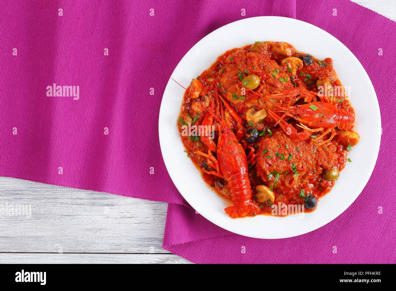 Huhn Marengo - Huhn Fleisch Eintopf mit crawfishies, gehackt Tomatensauce, Zwiebeln, Pilze, Oliven, auf die Platte an der Küche aus Holz Bretter mit Tisch mat Stockfoto