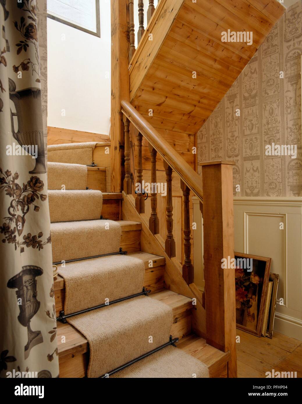 Holztreppe mit cremefarbenen Teppich und cremefarbene Tapete im Flur Stockfoto