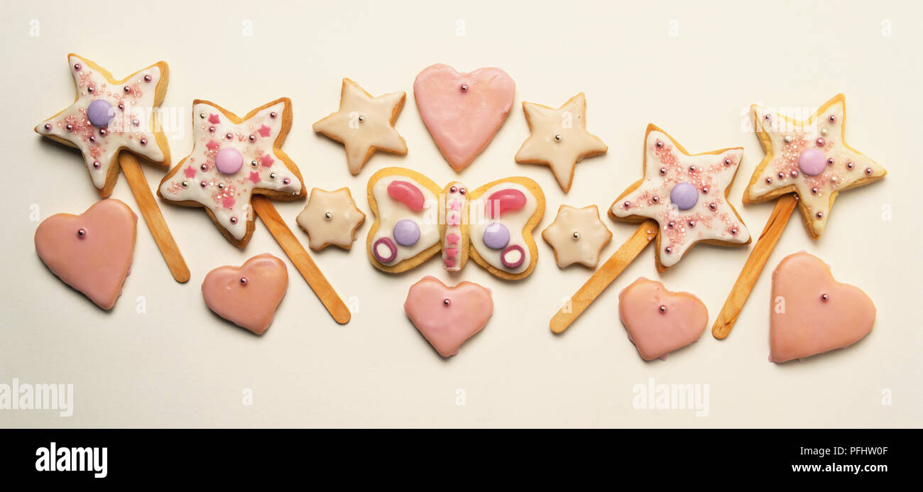 Sortiment von Stern- und Herzform Kekse, dekoriert mit rosa Zuckerguss. Stockfoto