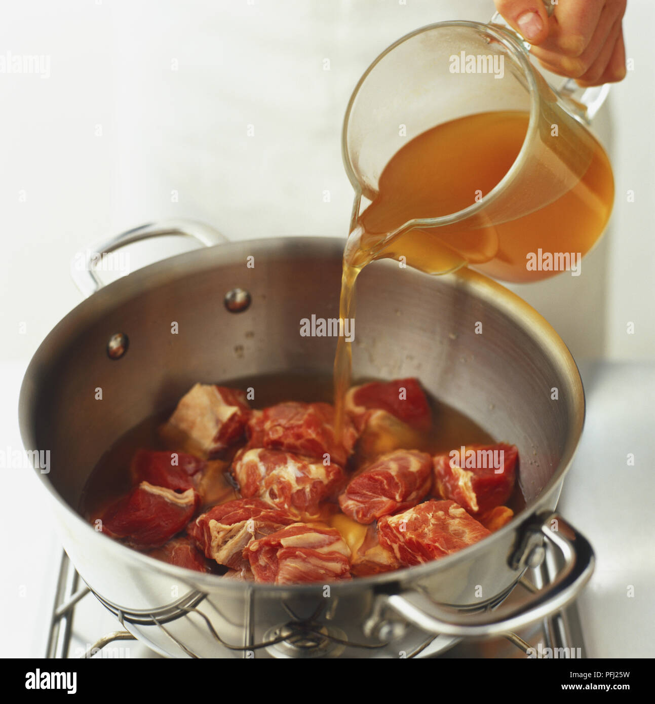 Lamm Lager über Stücke von Lammfleisch in Metall Topf, hohe Betrachtungswinkel geschüttet wurde Stockfoto