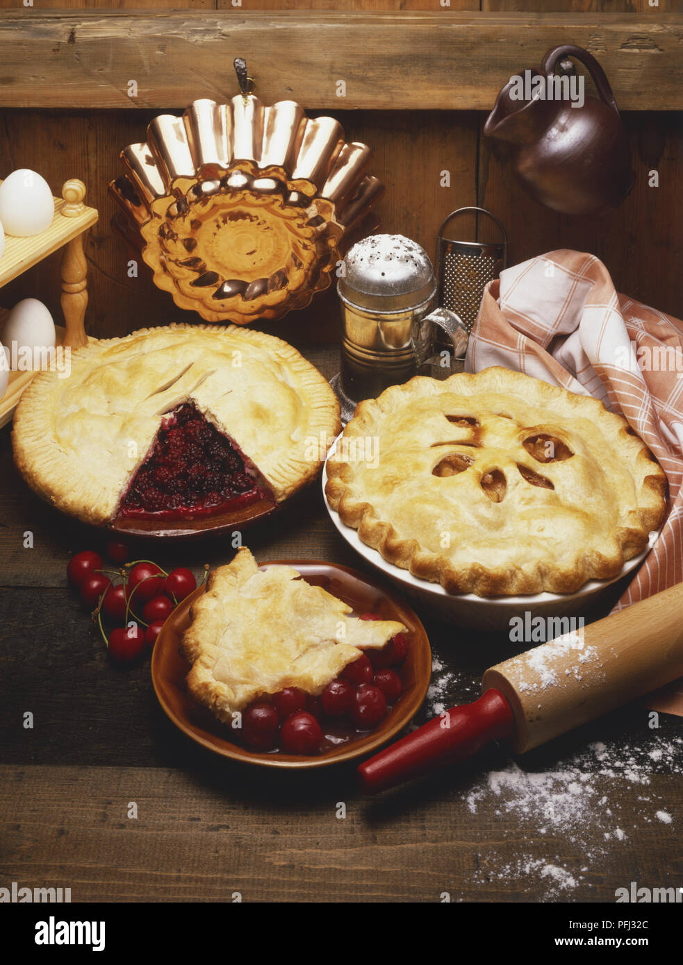 Cherry Pies, Zutaten und Küchengeräte auf einem Holztisch, hohe Betrachtungswinkel Stockfoto