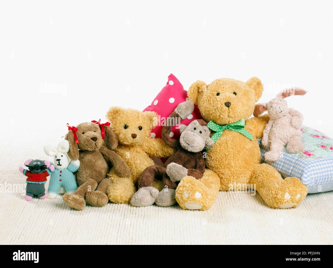 Reihe von Soft toys Sitzen und Stehen gegen Auflagen Stockfoto