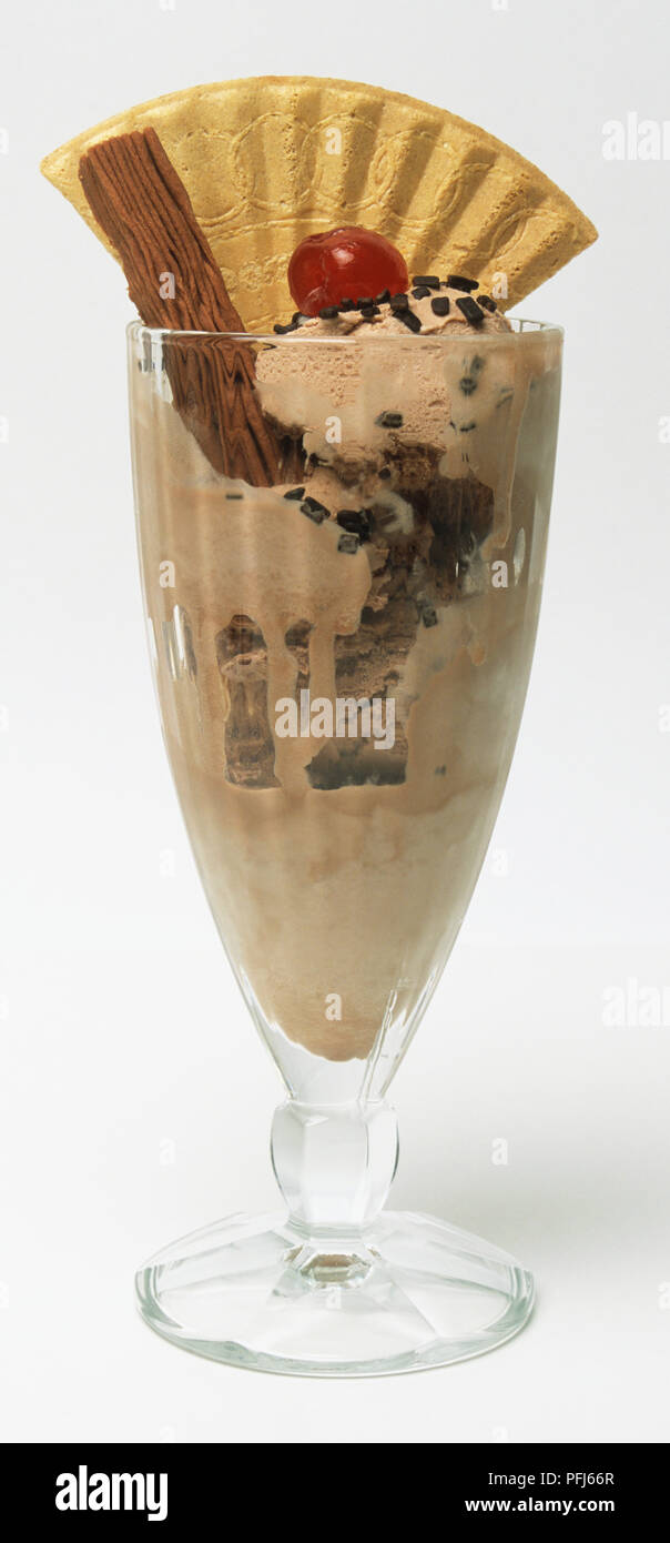 Schokoladeneis garniert mit Wafer- und Kirsche, in einem Glas serviert. Stockfoto