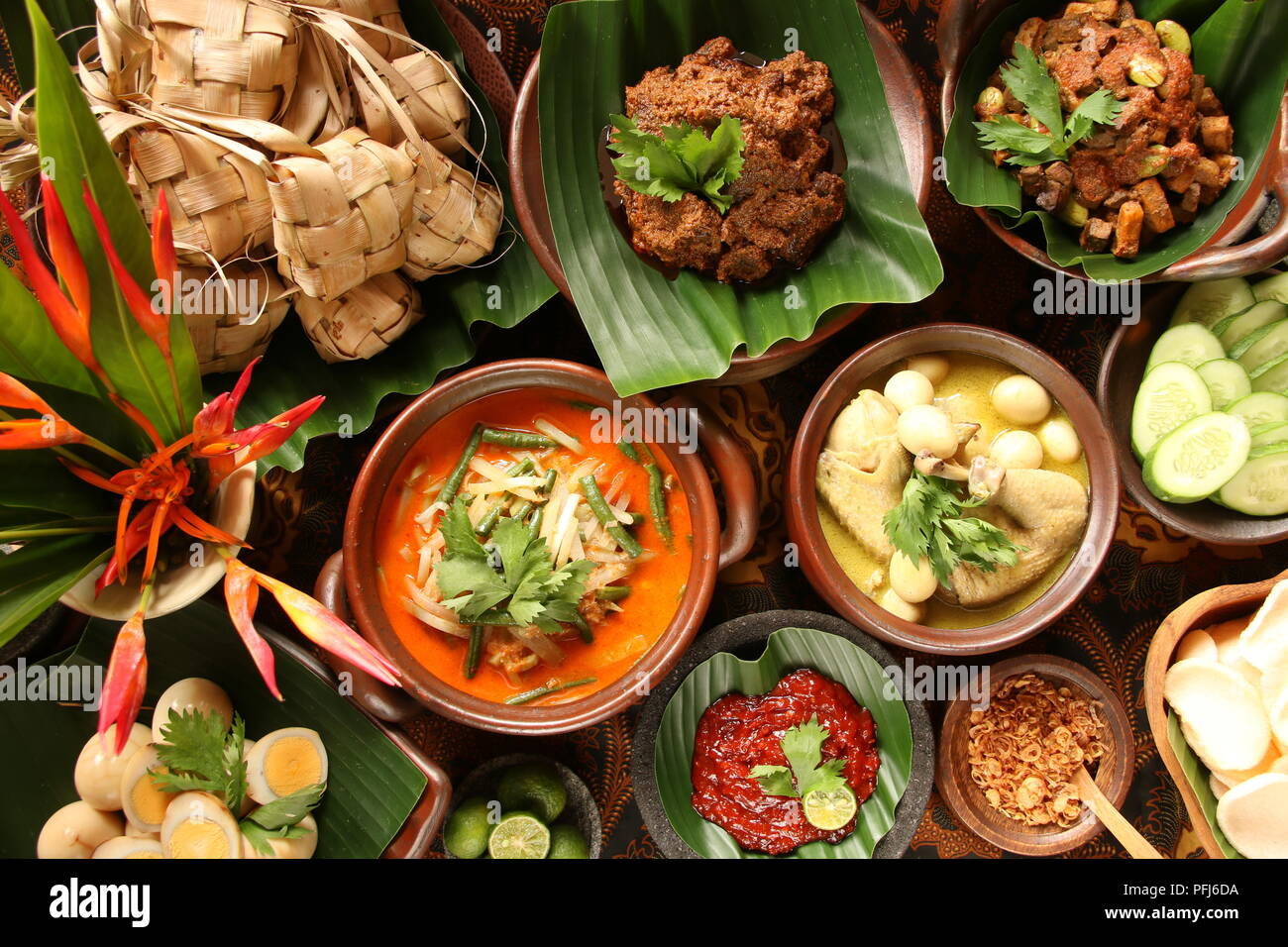 Ketupat Lebaran, die traditionelle feierliche Reisgericht mit Kuchen mit mehreren Beilagen; beliebt während Eid feiern. Stockfoto