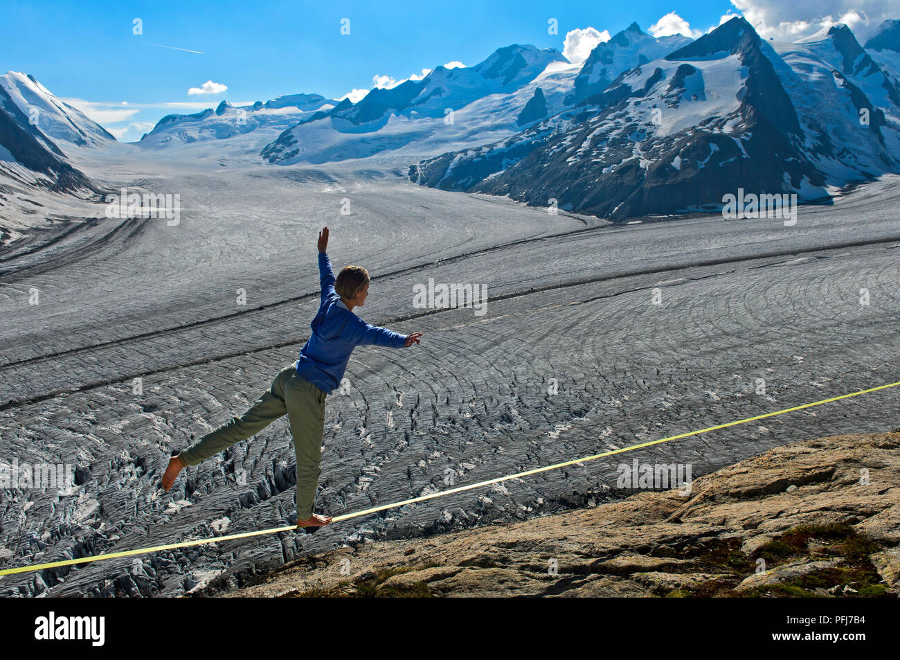 Junge Frau Balancieren auf der slackline an der Konkordia Hütte über den Gletscher Eis an den Konkordiaplatz, Berner Alpen, Wallis, Schweiz Stockfoto