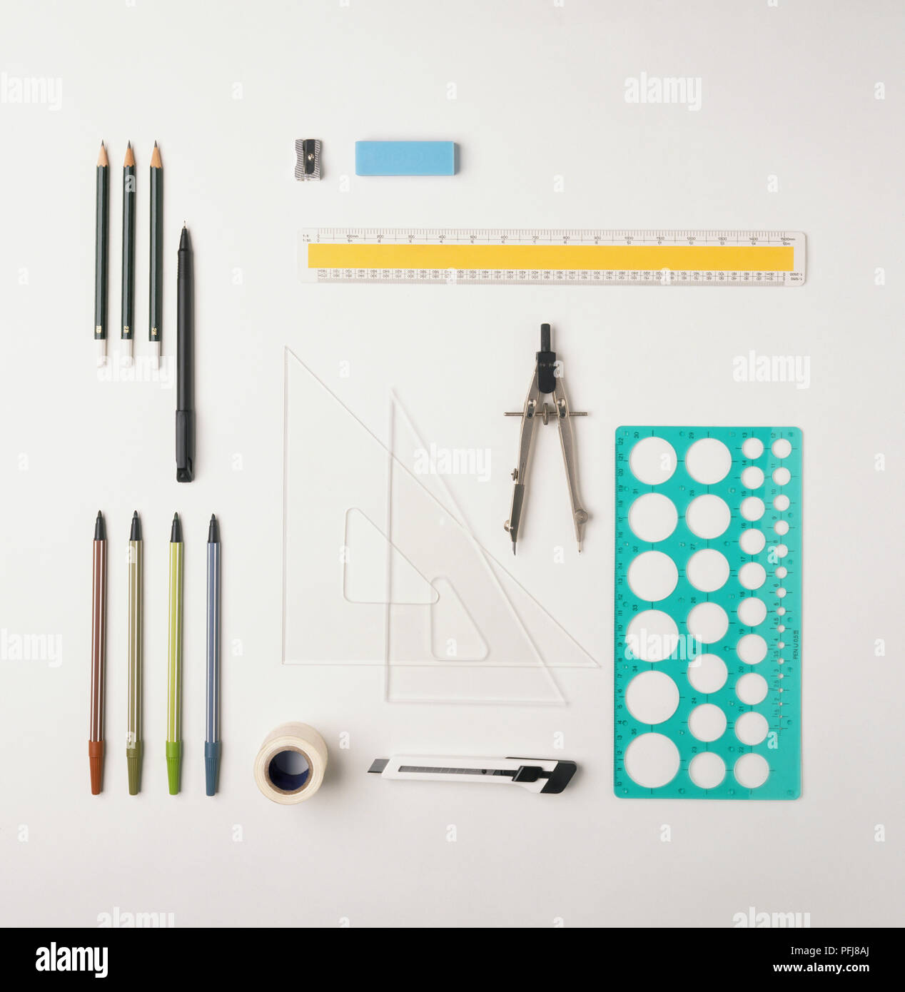 Lineal, Kompass, Messer, Schablone, Kugelschreiber, Bleistifte, Anspitzer, Radiergummi, Kunststoff rechtwinklige Dreiecke, Selbstklebeband, Teppichmesser, Ansicht von oben. Stockfoto