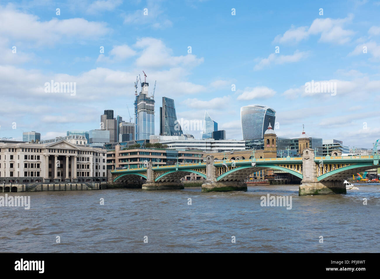Die Southwark Bridge über die Themse in London mit der Stadt London Financial District im Hintergrund Stockfoto