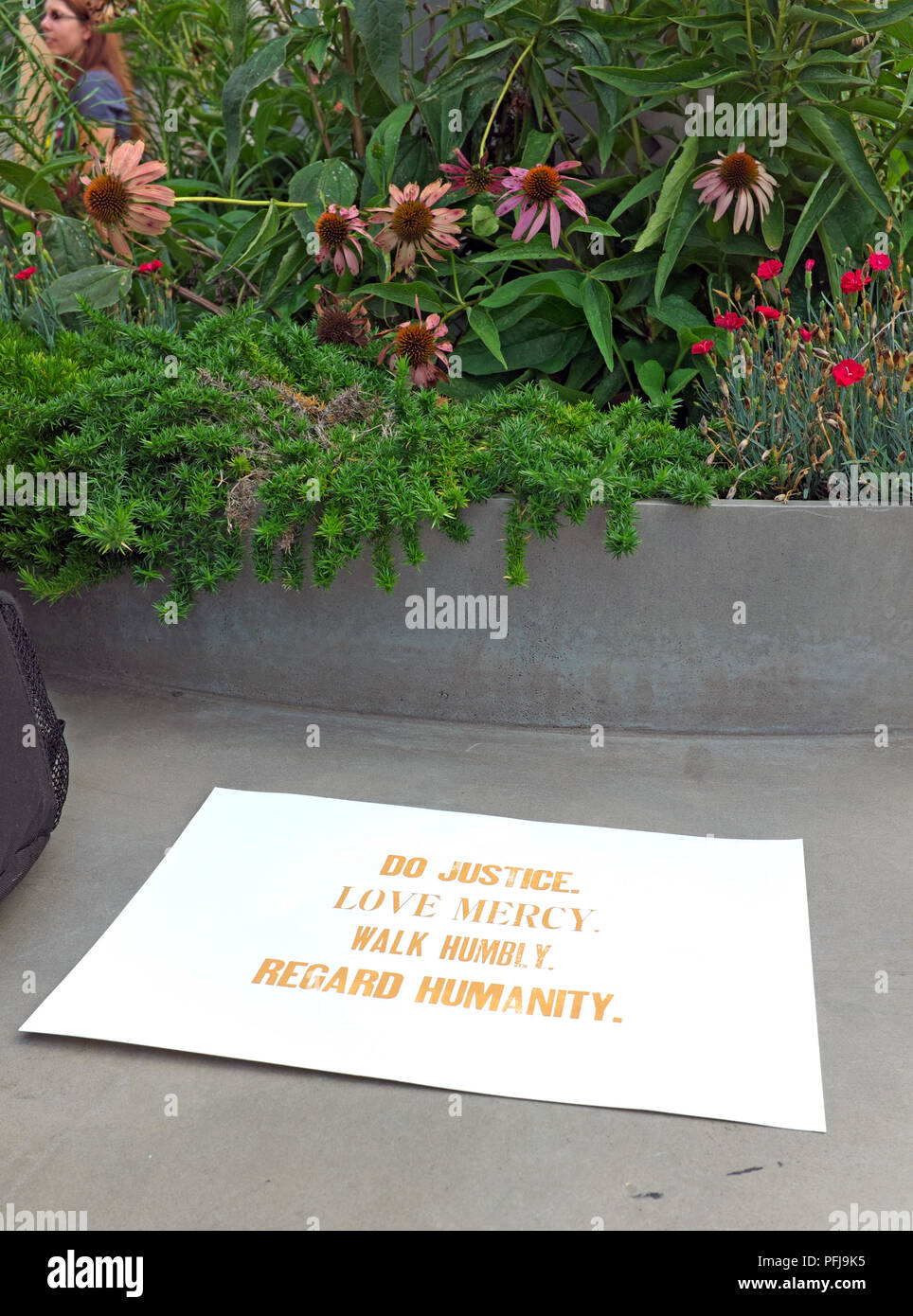 Ein Schild an einem öffentlichen Sitzbereich in Freedom Park in Washington, DC, - Tun der Gerechtigkeit, der Liebe, der Barmherzigkeit, der demütig wandeln und auf die Menschheit. Stockfoto