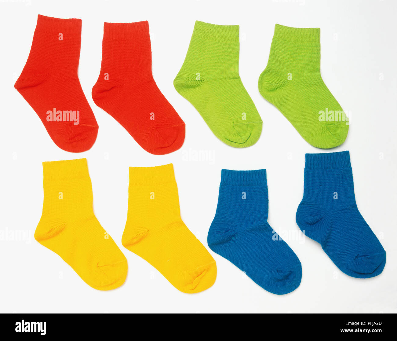 Vier Paar Socken, Rot, Grün, Gelb und Blau. Stockfoto