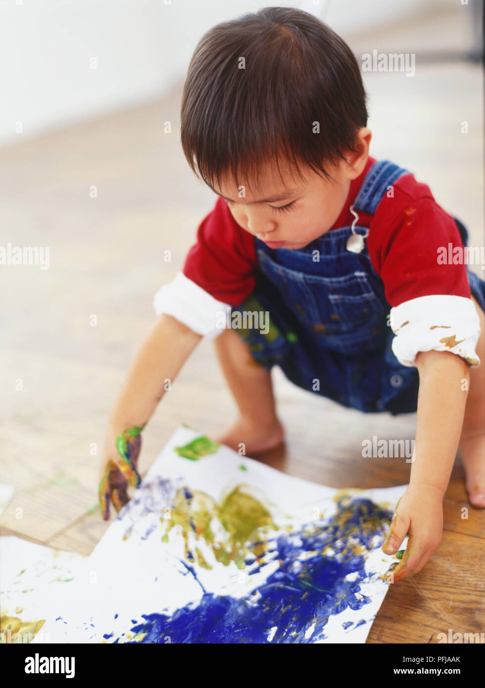 Junge kniend die Malerei zu holen Stockfoto