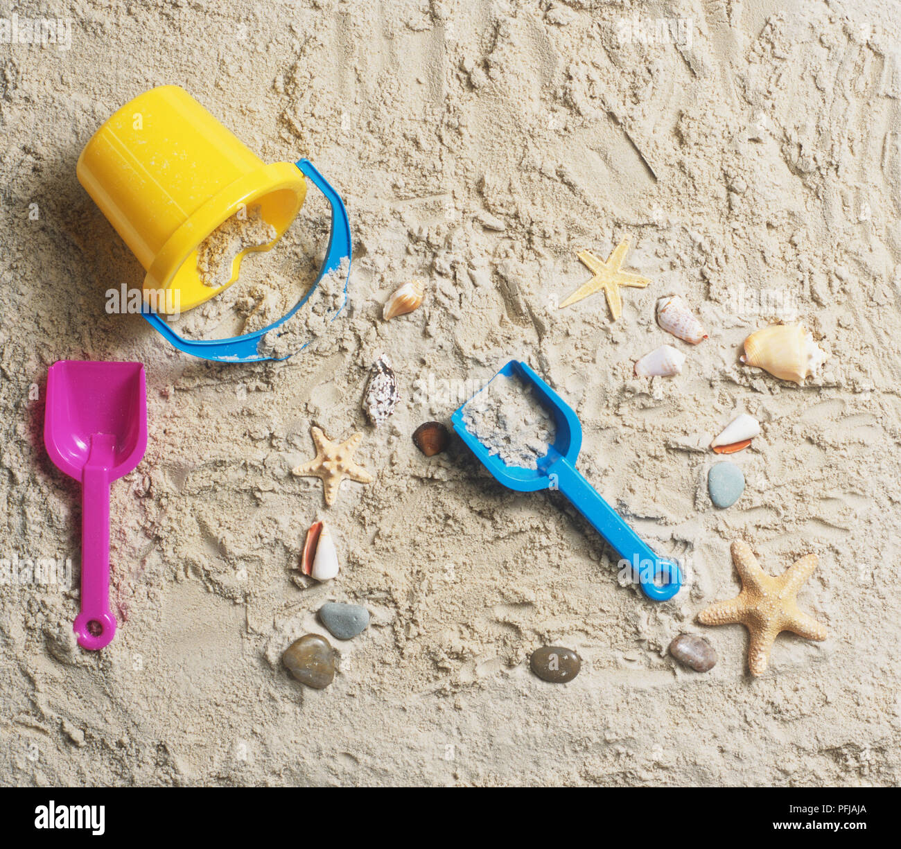 Trinkgeld - über Schaufel, Spaten, Steine, Muscheln und Seesterne auf Patch von Sand, Ansicht von oben Stockfoto