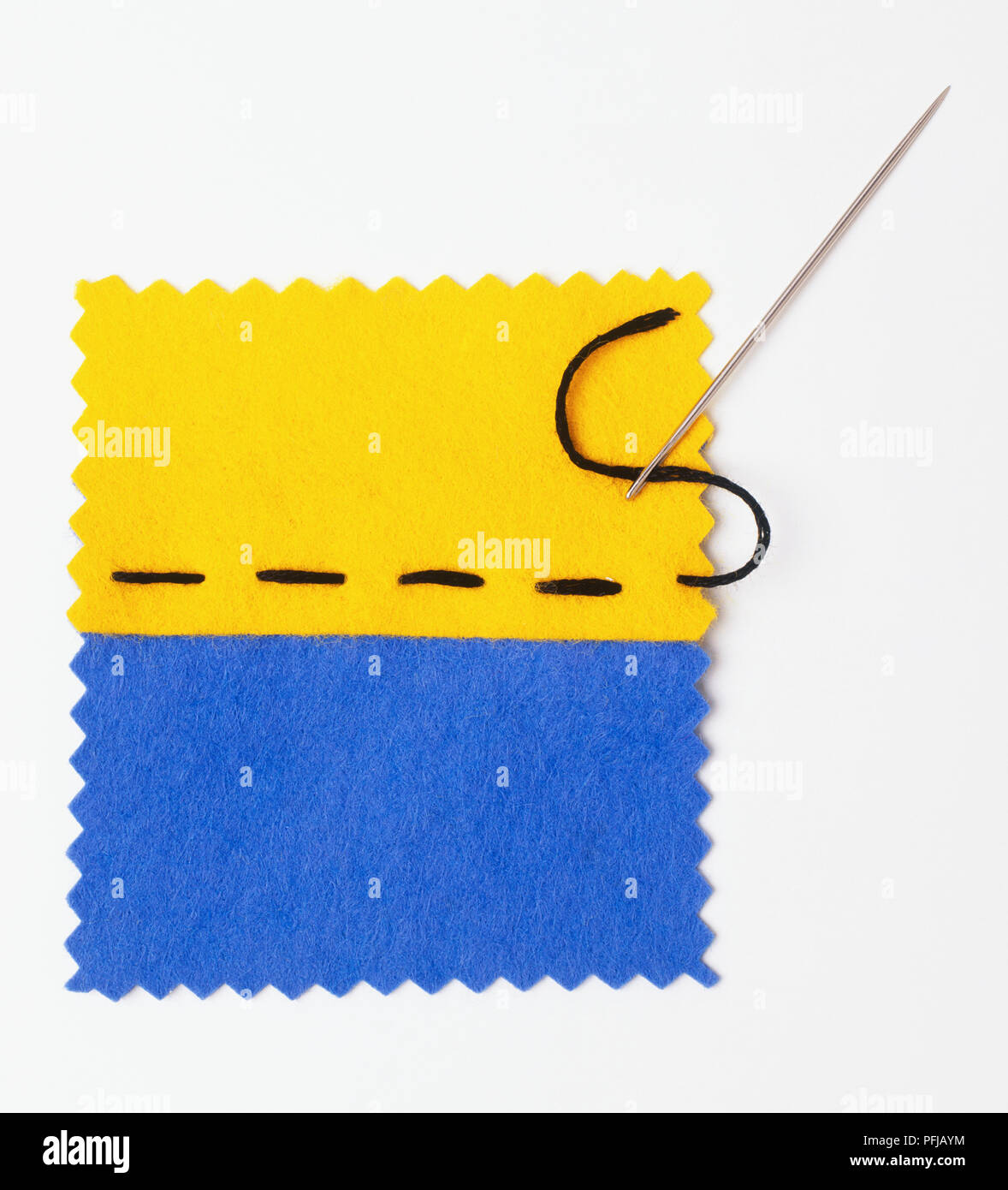 Patches von gelben und blauen Stoff zusammengenäht werden mit einfachen Stichen Stockfoto