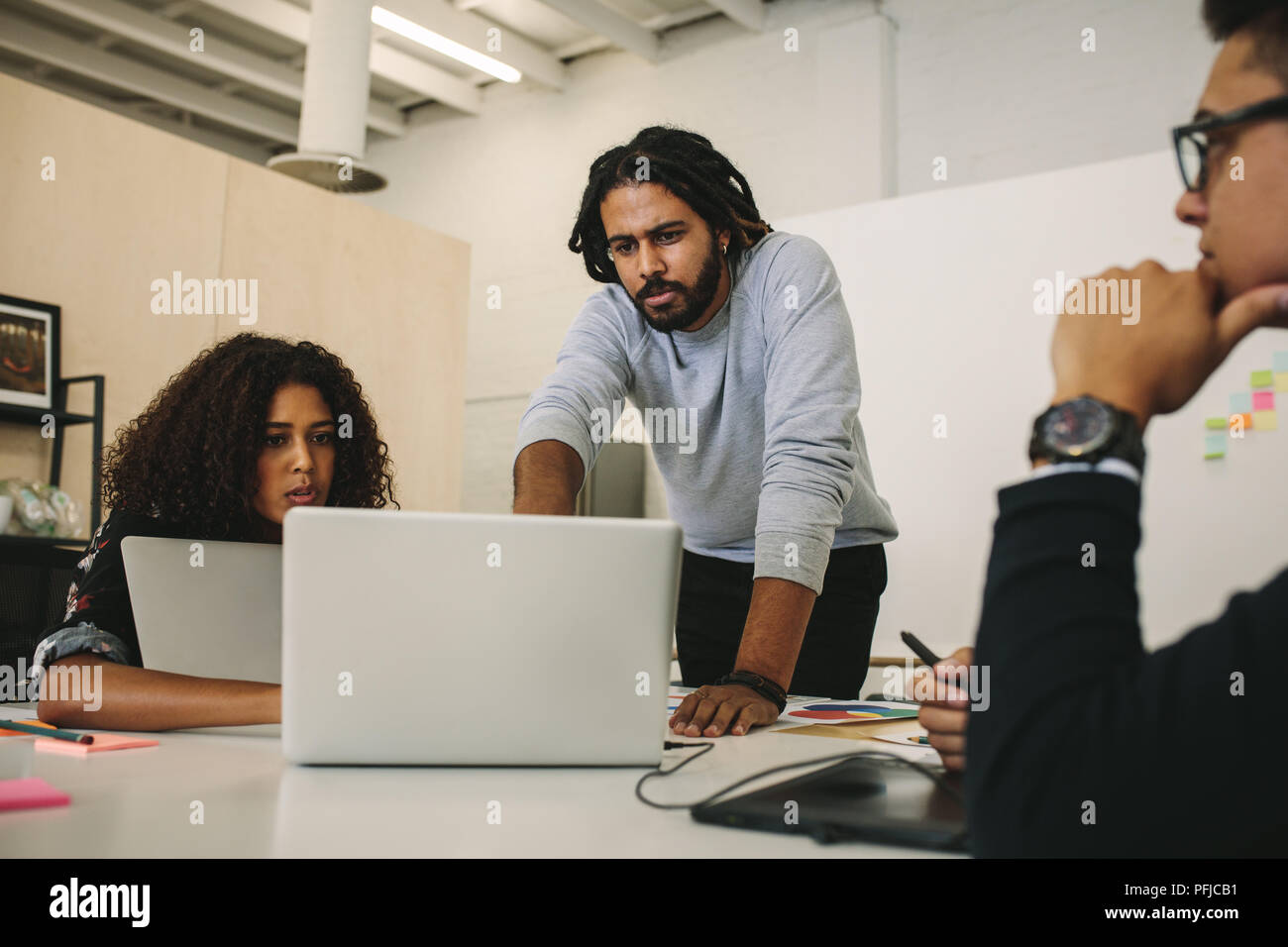 Unternehmer, die auf Laptops Ideen diskutieren. Kollegen in einem Brainstorming Ideen zu teilen. Stockfoto