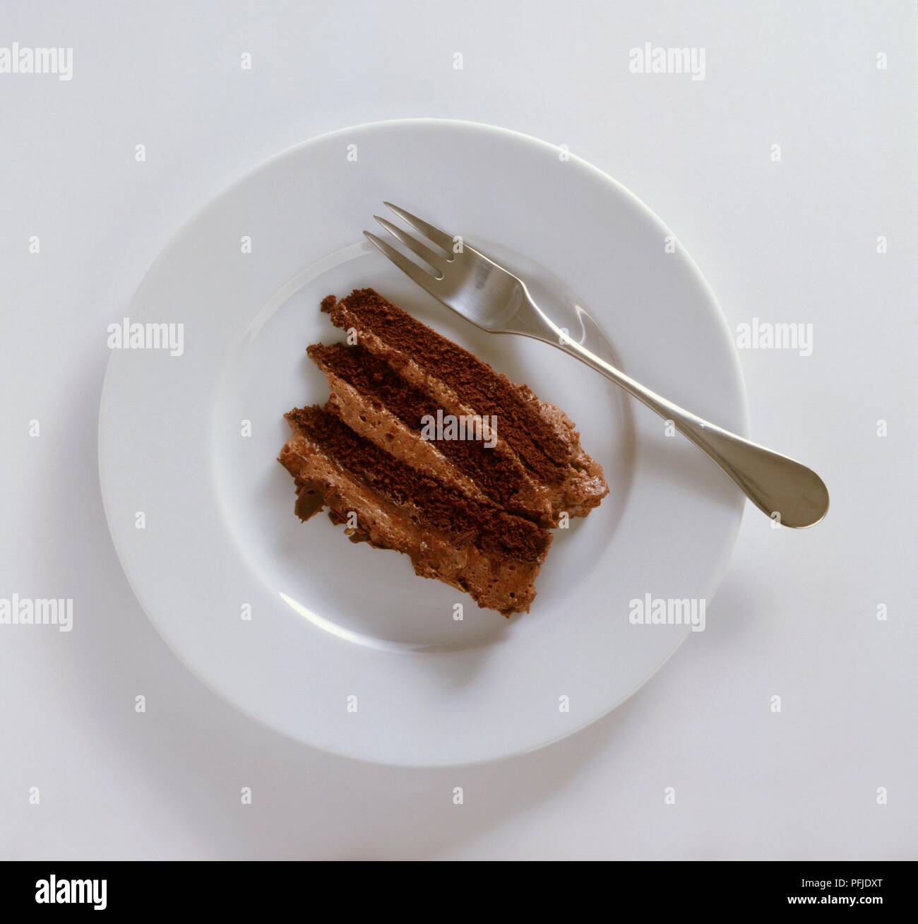 Stück Schokoladenkuchen auf weißer Teller mit Gabel Stockfoto