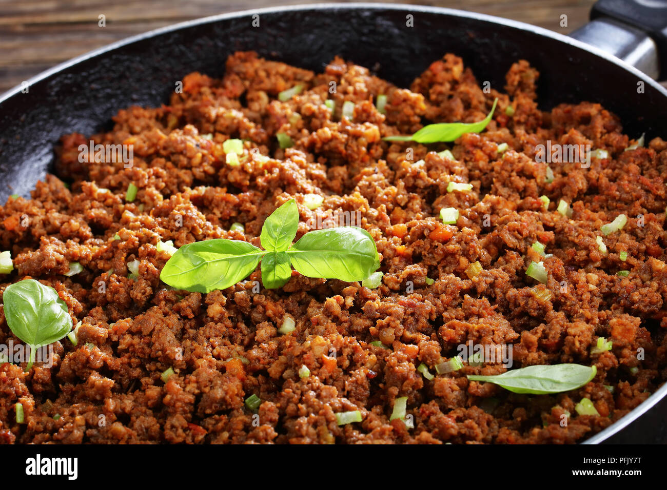 In der Nähe von Hot Juicy Rinderhackfleisch geschmort mit Tomatensauce, Gewürze, Basilikum, fein gehackt Gemüse und Sellerie in der Pfanne, klassisches Rezept, Seite vi. Stockfoto