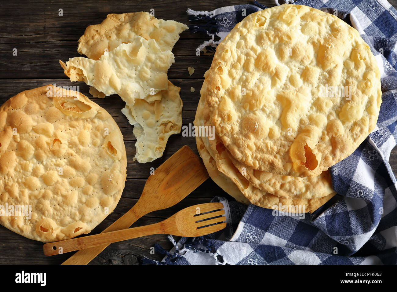 Close-up einfach hausgemachter Hefe freie knusprige vegane Weizen Fladen auf Holztisch mit Küchentuch und Spachteln, einfaches Rezept, Ansicht von oben Stockfoto