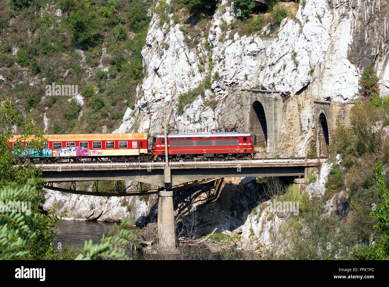 Bulgarien, Zug auf der Brücke über den Fluss nähern Tunnel durch den Berg Stockfoto