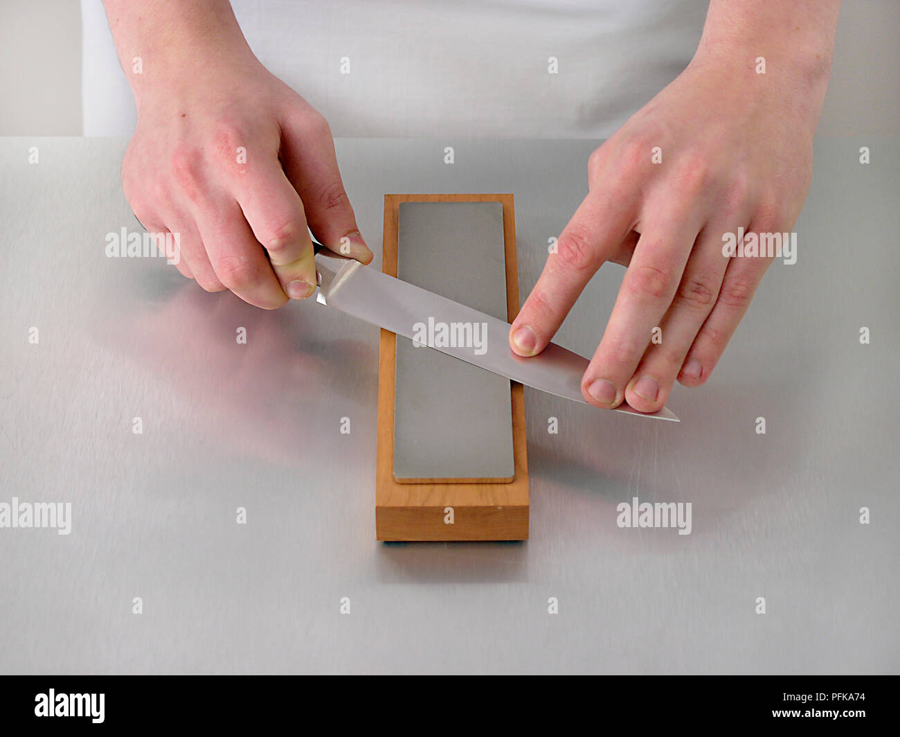 Hände Schärfen der Messer auf schärfblock, close-up Stockfoto