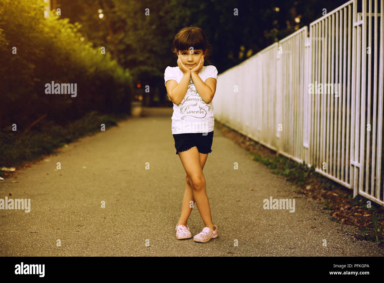 Porträt eines kleinen Mädchens, posiert in Park während der Abendstunden. Stockfoto