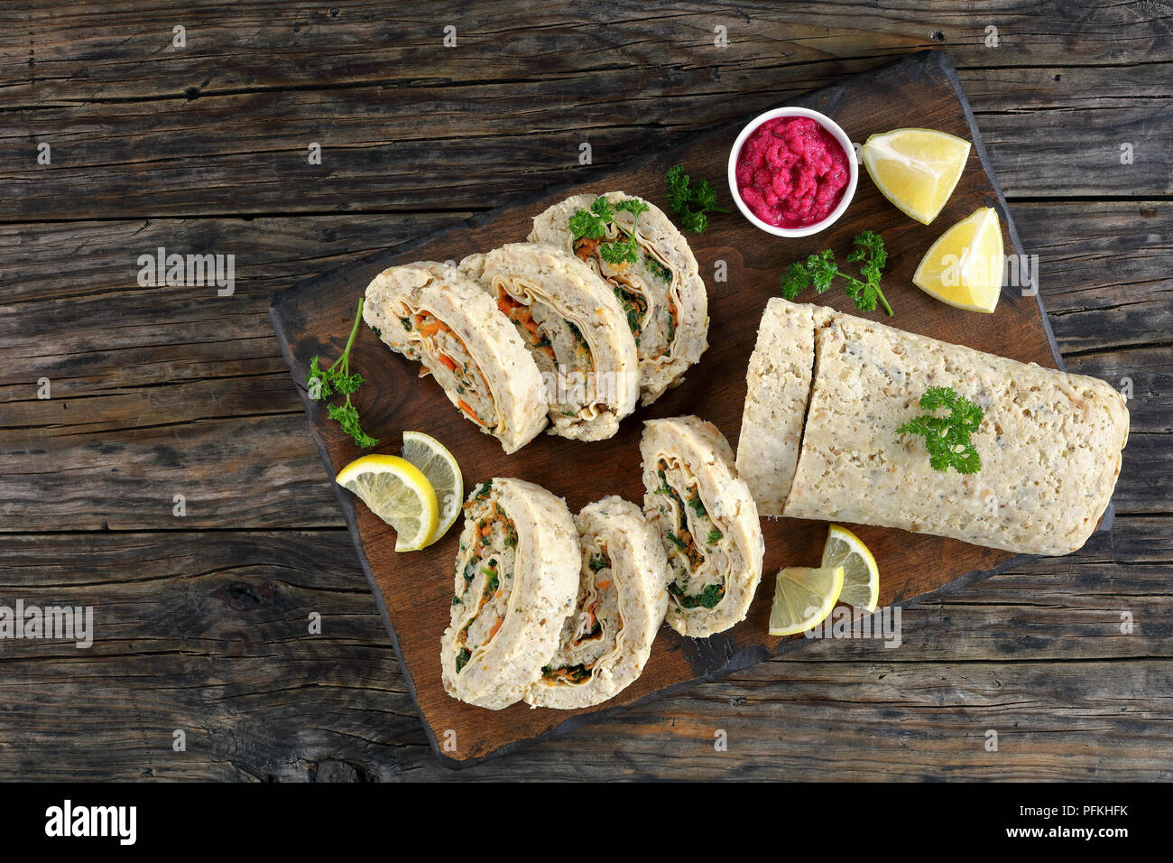 Lecker Fisch Roulade vom Boden Fisch Filet gefüllt mit Karotten, Käse und Grüns auf Holz Schneidebrett mit hausgemachten Meerrettich rote Bete Stockfoto