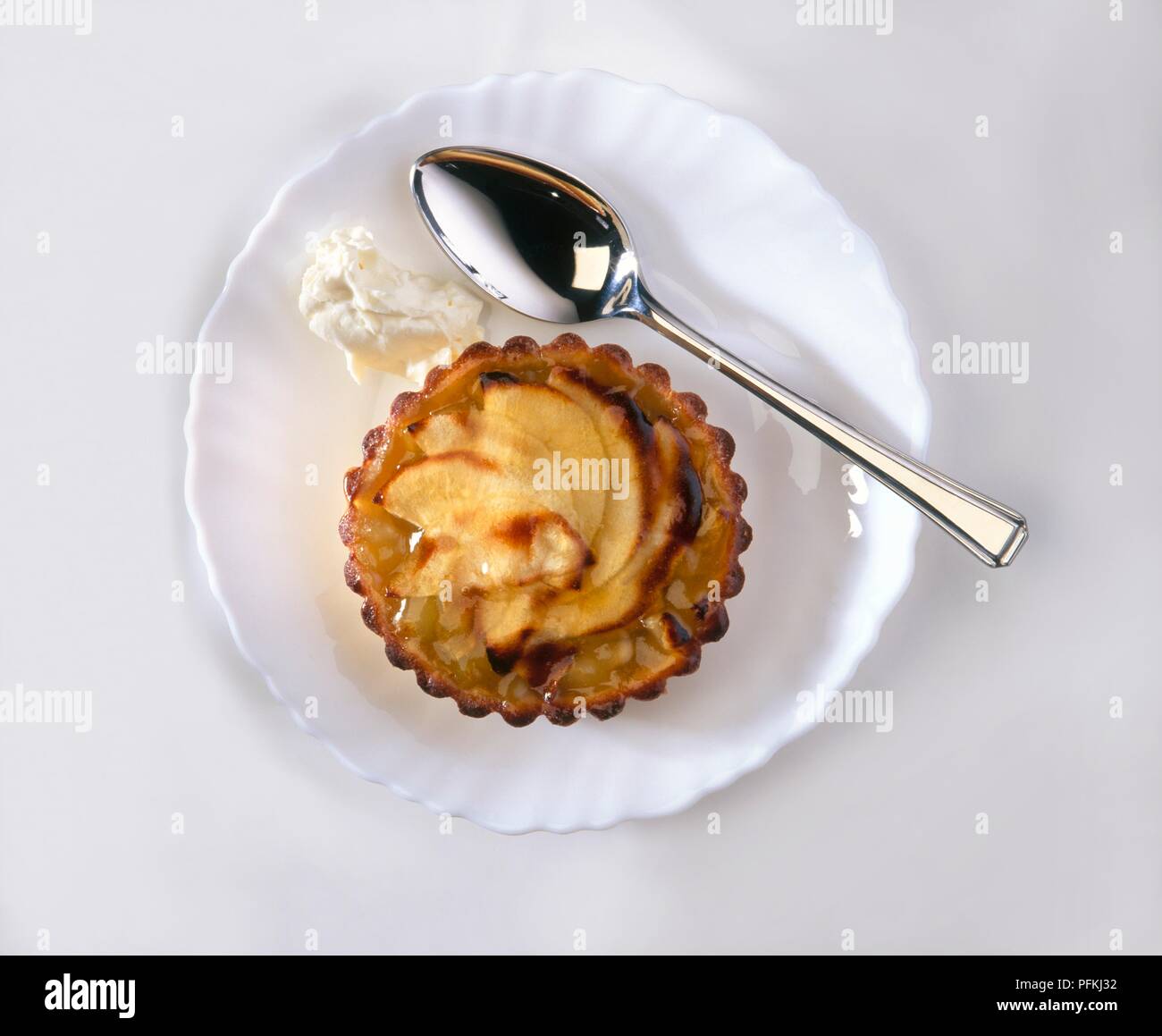 Apple Törtchen mit Clotted Cream, auf Platte, mit Löffel, Nahaufnahme, Ansicht von oben Stockfoto