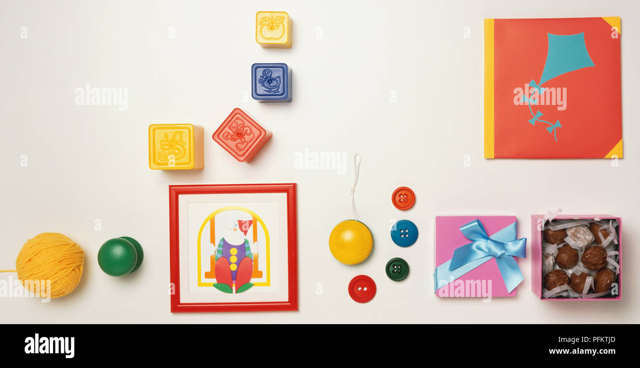 Rosa Schachtel Pralinen öffnen, farbigen Tasten, Yo-yo, Briefmarken, Ball der gelbe Wolle, gerahmtes Bild eines Clowns, Karte mit Kite Illustration, Stockfoto