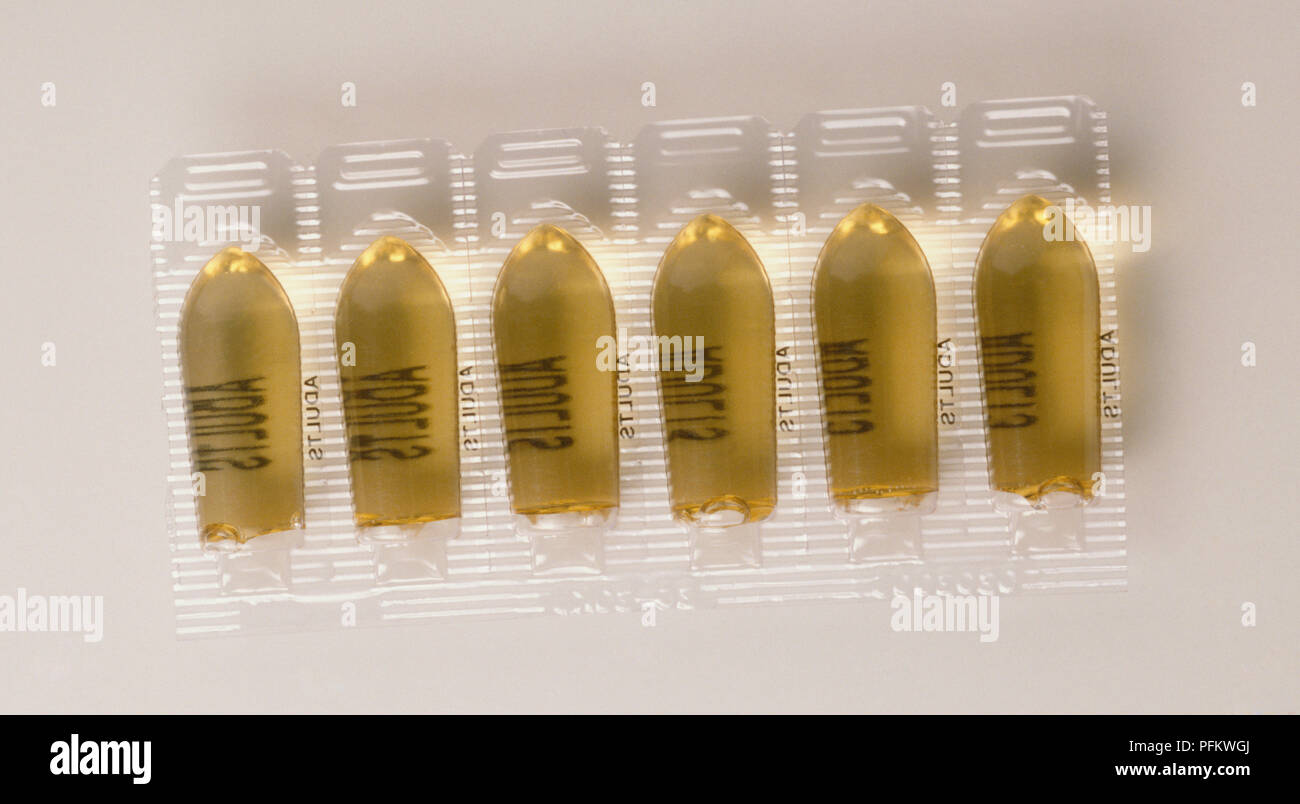 Sechs gelbe Zäpfchen Kapseln in klaren Kunststoff Fach, aus der Nähe. Stockfoto