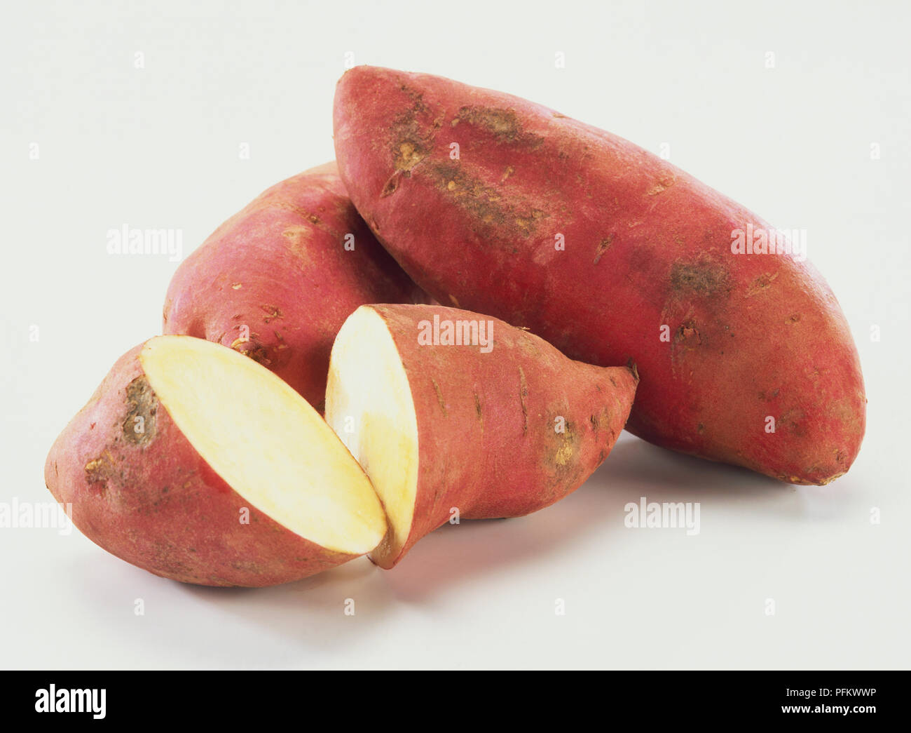 Ipomoea batatas, Süße Kartoffeln, ganz und geschnitten. Stockfoto