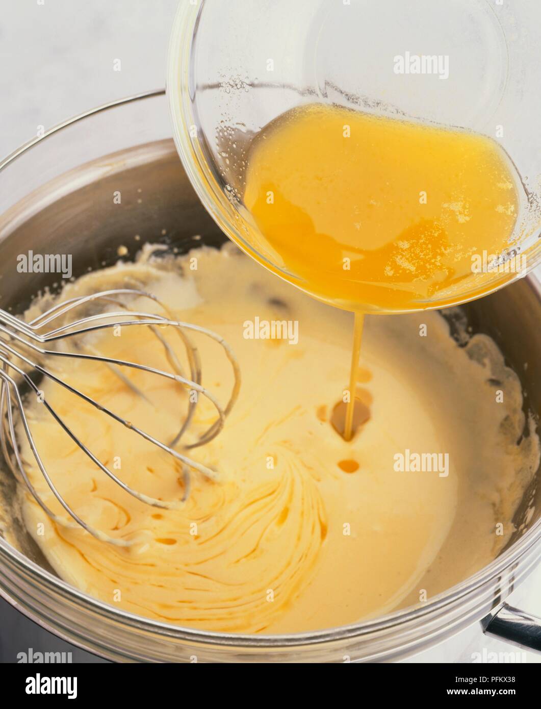 Gießen geschmolzene Butter in Zitrone Sauce Hollandaise und rühren in der Schüssel Stockfoto