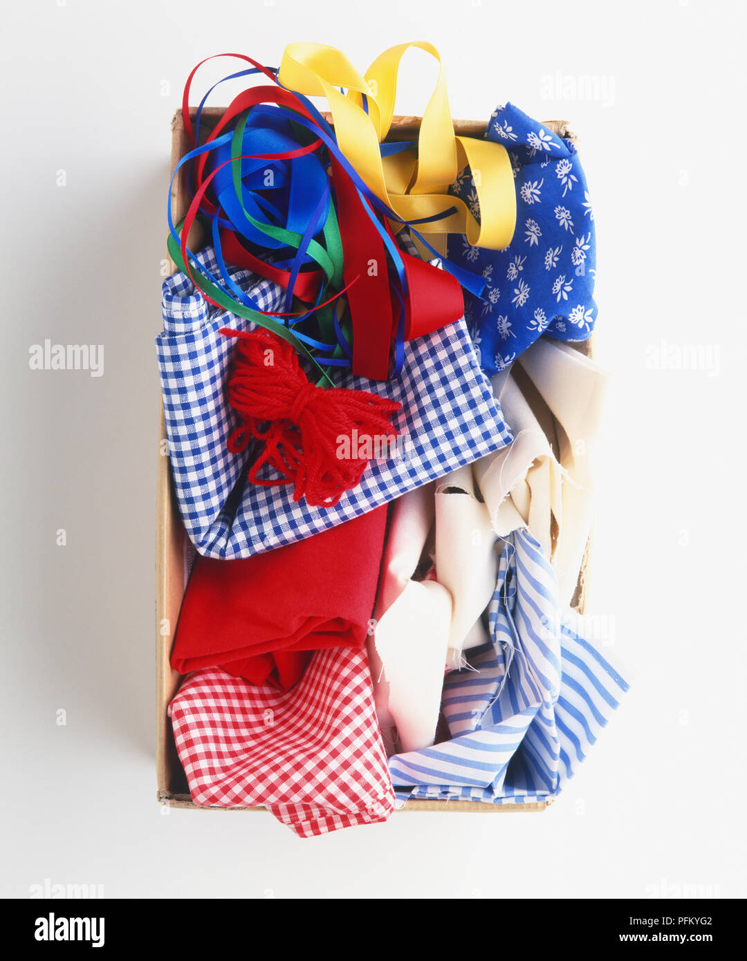 Schuhkarton mit Ersatzteile Bits von farbigen Garnen, bunten Bänder, Reste von Plain und gemusterten Stoff, Ansicht von oben Stockfoto