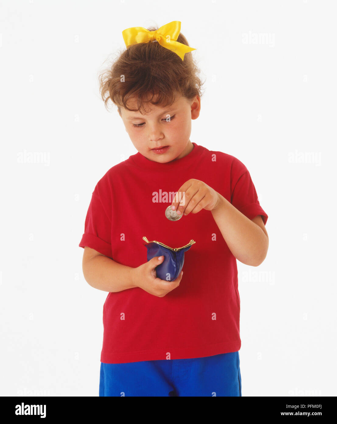 Mädchen fallen Münzen in eine Schwarze Geldbörse Stockfoto