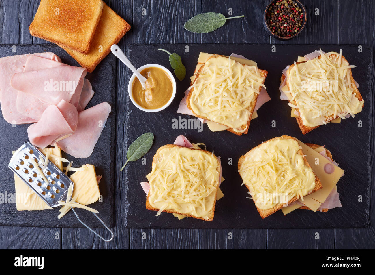 French Toast Croque Monsieur vorbereitet zu backen. geröstetes Brot mit Butter Scheiben gekochten Schinken und Emmentaler Käse auf ein Backblech und Zutaten o Stockfoto