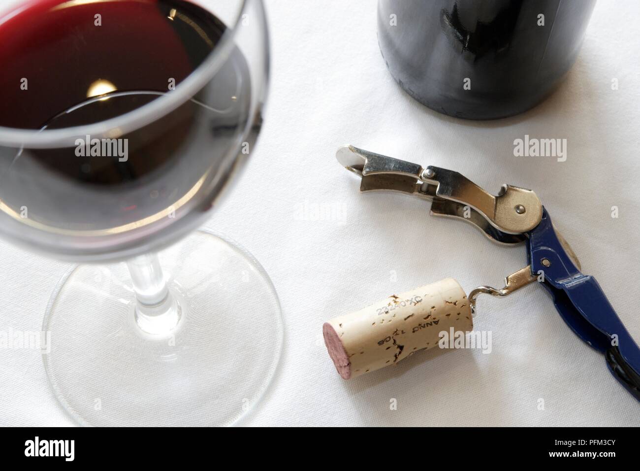 Korkenzieher mit Cork neben Glas Rotwein Stockfoto