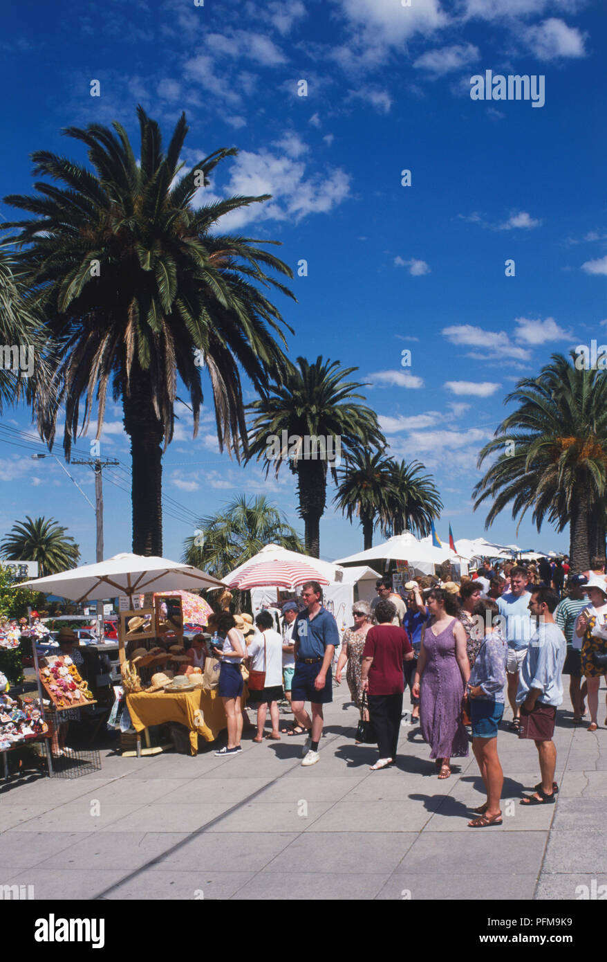 Australien, Melbourne, St Kilda Esplanade, Menschenmassen, Handwerkermarkt am von Palmen gesäumten Boulevard. Stockfoto