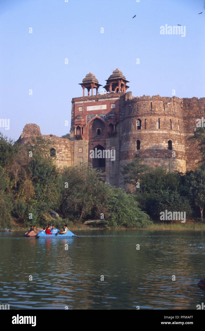 Indien, Delhi, Purana Qila, d. h. alte Fort, alte Festung auf einem alten Damm, solide Sandsteinwände, zwei Chhatri mit dekorativen Kacheln, runden Wänden mit kleinen Fenstern, Bootsfahrten auf dem See im Vordergrund. Stockfoto