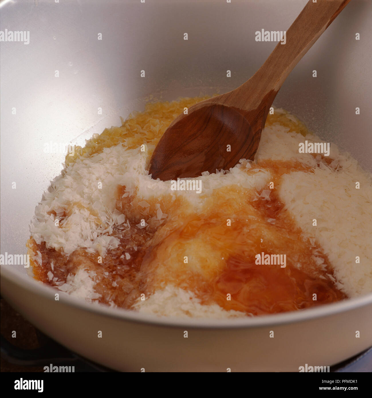 Mischen soapflakes, Honig und Öl zusammen mit Holzlöffel, selbstgemachte Seife. Stockfoto